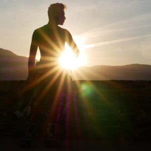 motard a moitié équipé devant les dernier rayons de soleil